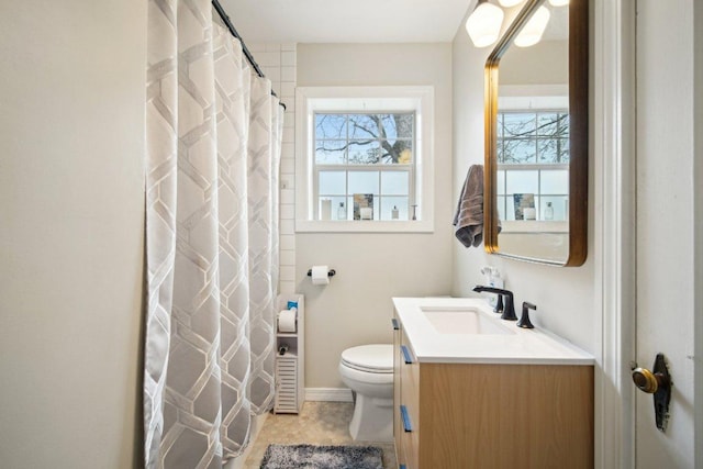 bathroom with toilet, vanity, and baseboards