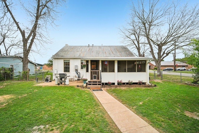 view of front of house with a sunroom, a fenced backyard, a front yard, and entry steps