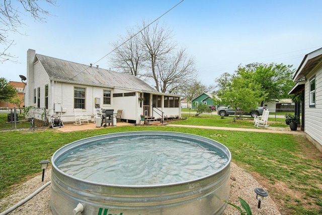 exterior space featuring entry steps, a sunroom, fence, and a yard