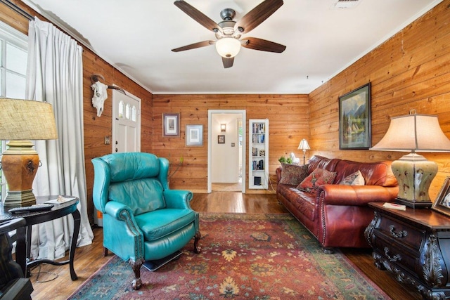 living room with visible vents, wood finished floors, and ceiling fan