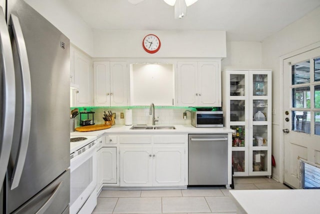 kitchen featuring white cabinetry, light countertops, decorative backsplash, a sink, and appliances with stainless steel finishes