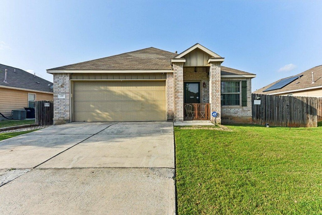 218 Wells Bnd, Hutto, TX 78634 - view of front of home featuring concrete driveway, an attached garage, and brick siding