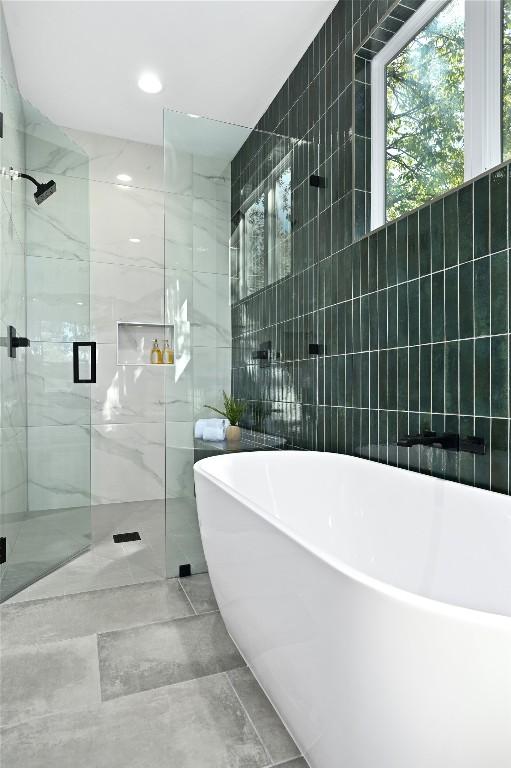 3004 Ray Wood Dr, Austin, TX 78704 - full bathroom with tile walls, a marble finish shower, and a freestanding tub