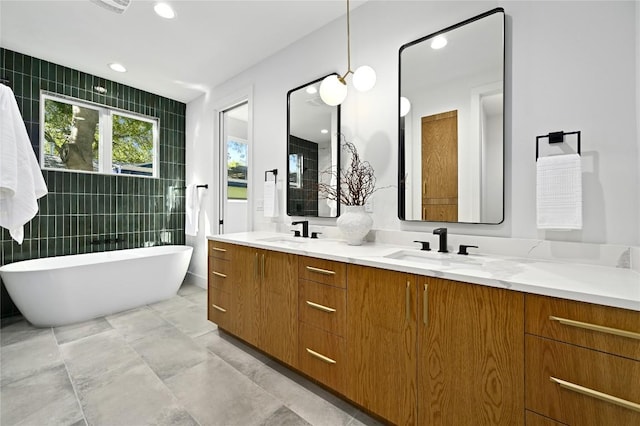 3004 Ray Wood Dr, Austin, TX 78704 - full bathroom featuring double vanity, a freestanding tub, and tile walls