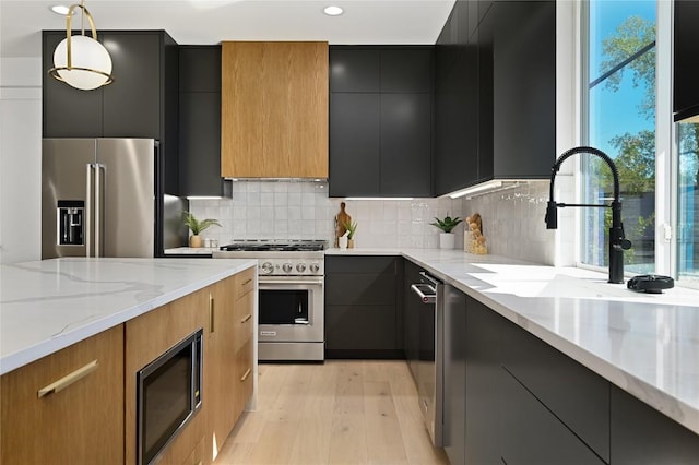 3004 Ray Wood Dr, Austin, TX 78704 - kitchen featuring high quality appliances, modern cabinets, dark cabinets, light stone counters, and recessed lighting