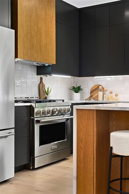 3004 Ray Wood Dr, Austin, TX 78704 - kitchen with stainless steel appliances, dark cabinetry, modern cabinets, light countertops, and decorative backsplash