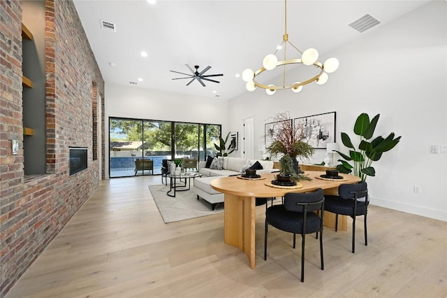 3004 Ray Wood Dr, Austin, TX 78704 - dining room featuring a chandelier, light wood-style flooring, a high ceiling, recessed lighting, and a brick fireplace