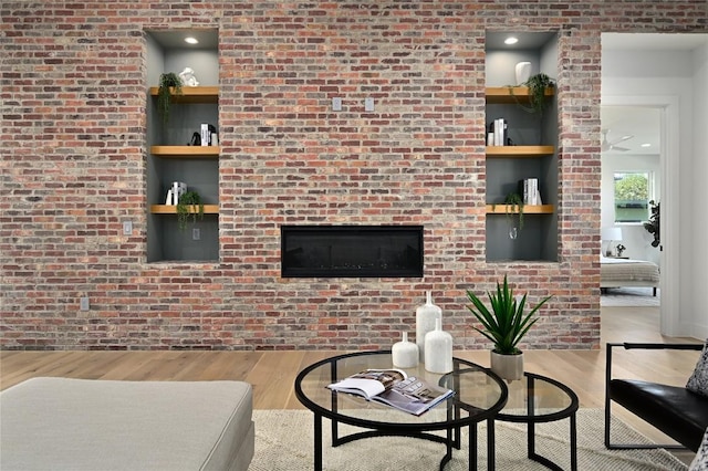 3004 Ray Wood Dr, Austin, TX 78704 - living room with wood finished floors, brick wall, and a glass covered fireplace