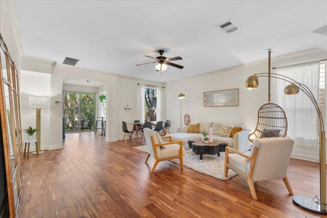 2608 Lightfoot Trl, Austin, TX 78745 - living room with arched walkways, ornamental molding, ceiling fan, and wood finished floors