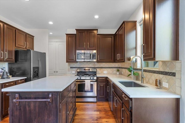 2608 Lightfoot Trl, Austin, TX 78745 - kitchen with appliances with stainless steel finishes, a sink, dark brown cabinetry, and recessed lighting