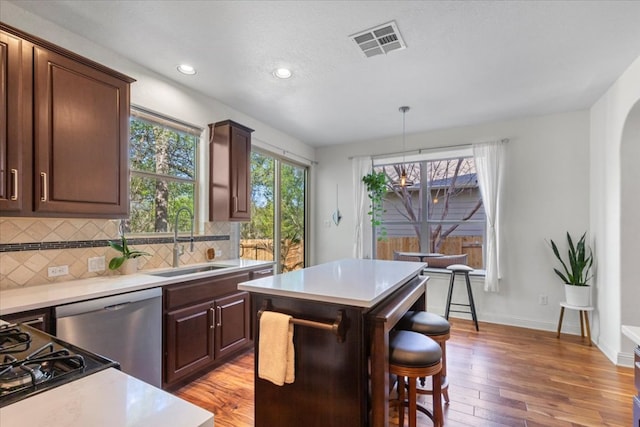 2608 Lightfoot Trl, Austin, TX 78745 - kitchen featuring a sink, dishwasher, light wood-type flooring, light countertops, and backsplash