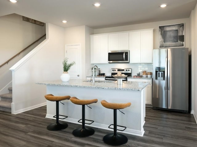 1850 Settlers Glen Dr Unit 601, Round Rock, TX 78665 - kitchen featuring tasteful backsplash, dark wood-type flooring, a sink, light stone counters, and appliances with stainless steel finishes