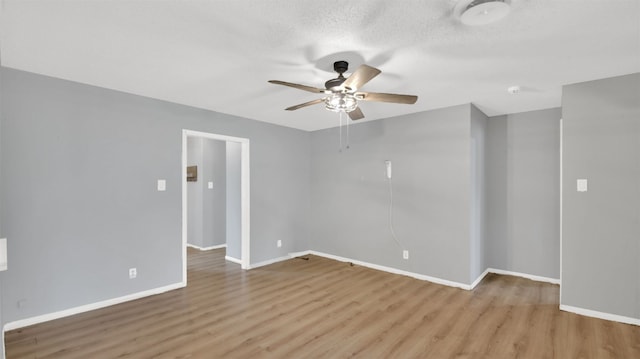 unfurnished room with wood finished floors, a textured ceiling, baseboards, and ceiling fan