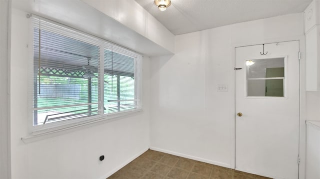spare room featuring baseboards and a textured ceiling