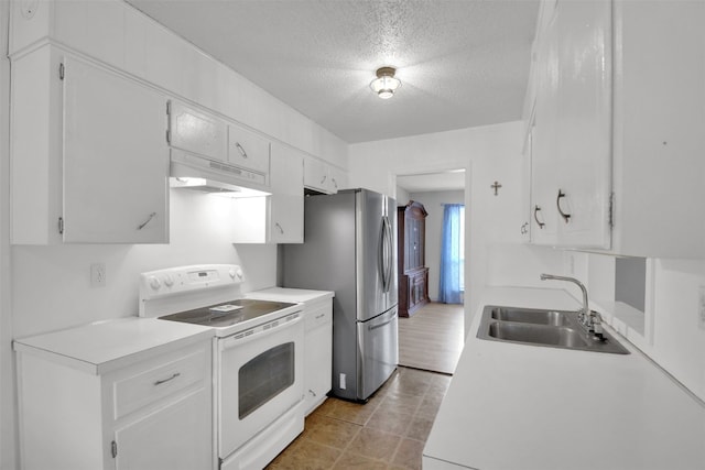 kitchen with light countertops, under cabinet range hood, electric stove, a sink, and freestanding refrigerator