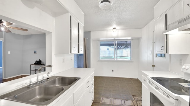 kitchen featuring light countertops, a textured ceiling, a sink, white electric range, and white cabinets