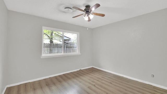 unfurnished room featuring a textured ceiling, baseboards, wood finished floors, and a ceiling fan