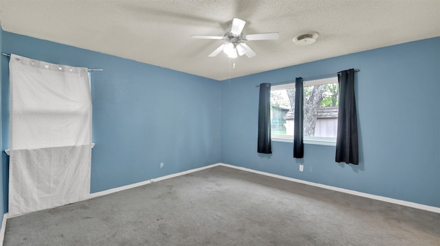 spare room with baseboards, ceiling fan, carpet flooring, and a textured ceiling