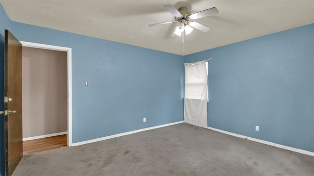 empty room with baseboards, ceiling fan, and carpet