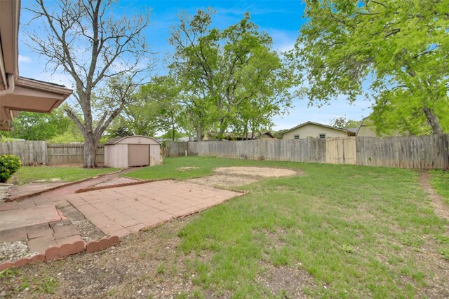 view of yard featuring a fenced backyard, a shed, an outdoor structure, and a patio