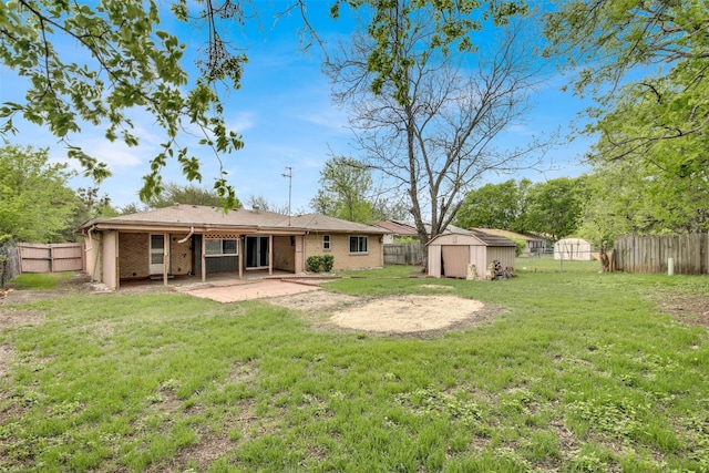 rear view of house featuring a patio, a fenced backyard, a storage unit, an outdoor structure, and a yard