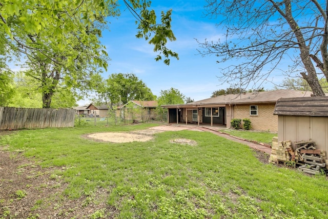 view of yard with a fenced backyard, an outdoor structure, and a patio area