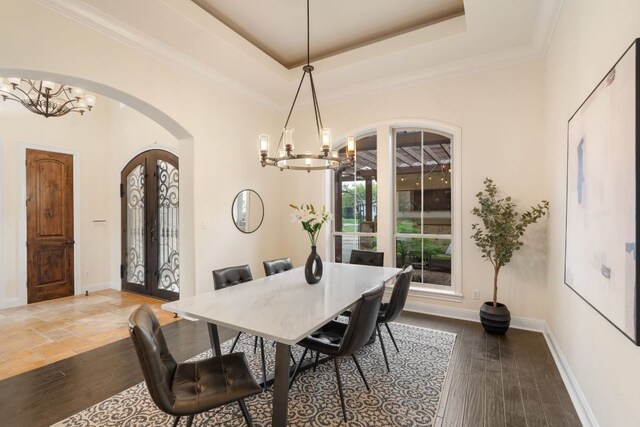 15086 Barrie Dr, Austin, TX 78734 - dining area with arched walkways, a chandelier, a tray ceiling, baseboards, and ornamental molding