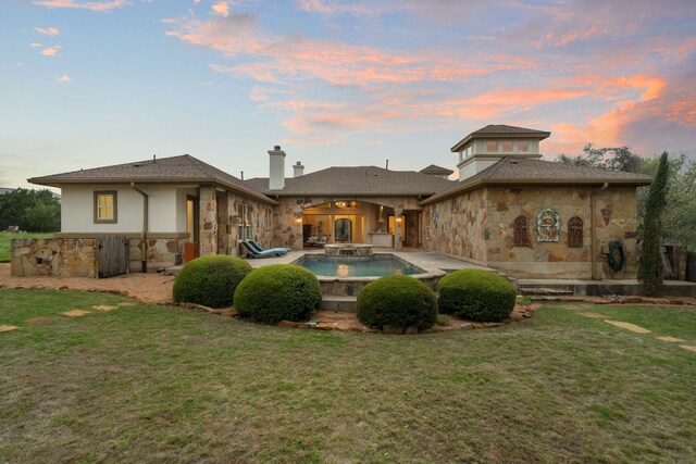 15086 Barrie Dr, Austin, TX 78734 - back of house featuring stone siding, a patio, a yard, and a chimney