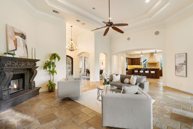 15086 Barrie Dr, Austin, TX 78734 - living area featuring arched walkways, a raised ceiling, a high ceiling, a ceiling fan, and stone tile floors