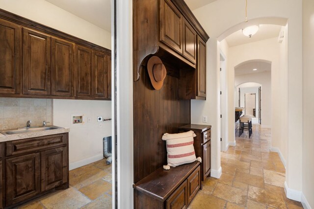 15086 Barrie Dr, Austin, TX 78734 - mudroom featuring stone tile floors, arched walkways, a sink, and baseboards
