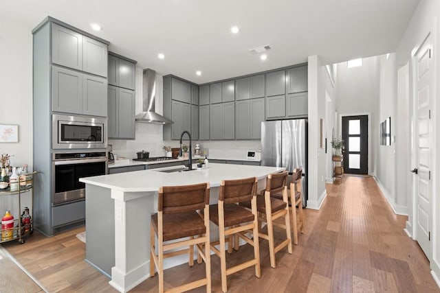 1213 Silver Dollar Trl, Georgetown, TX 78628 - kitchen featuring appliances with stainless steel finishes, wall chimney exhaust hood, gray cabinetry, and recessed lighting