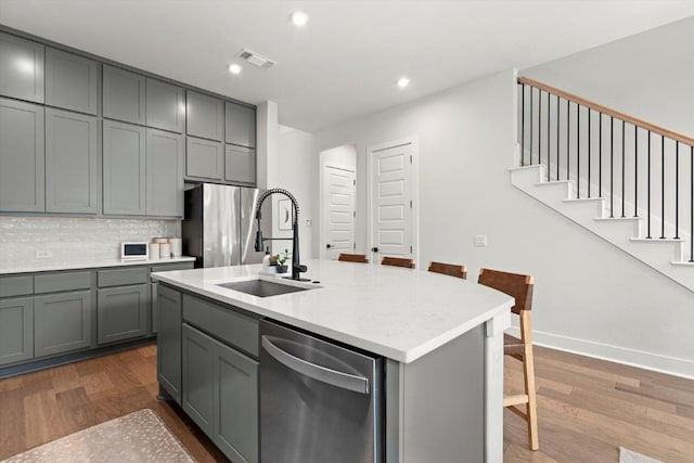 1213 Silver Dollar Trl, Georgetown, TX 78628 - kitchen featuring gray cabinetry, a sink, appliances with stainless steel finishes, dark wood-style flooring, and recessed lighting