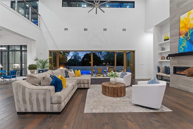 108 Fishspear Ln, Georgetown, TX 78628 - living room featuring a towering ceiling, built in features, wood finished floors, a fireplace, and a chandelier