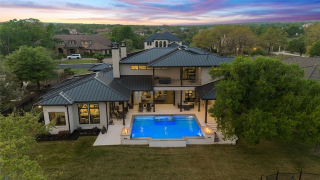 108 Fishspear Ln, Georgetown, TX 78628 - rear view of house with a standing seam roof, a balcony, metal roof, a yard, and a patio area