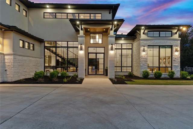 108 Fishspear Ln, Georgetown, TX 78628 - exterior entry at dusk featuring stone siding and stucco siding