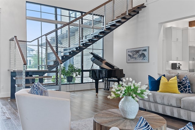 108 Fishspear Ln, Georgetown, TX 78628 - living area with stairway, plenty of natural light, a towering ceiling, wood finished floors, and baseboards