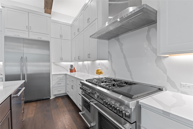 108 Fishspear Ln, Georgetown, TX 78628 - kitchen with high end appliances, wall chimney range hood, dark wood-type flooring, and white cabinetry