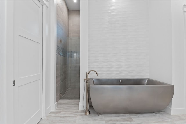 108 Fishspear Ln, Georgetown, TX 78628 - bathroom featuring a freestanding bath, a tile shower, baseboards, and marble finish flooring