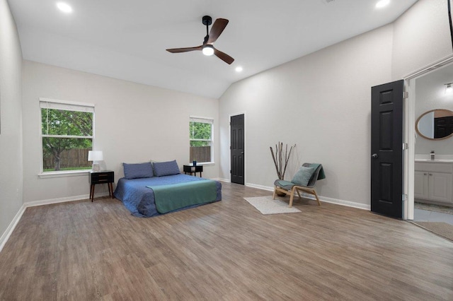 bedroom featuring baseboards, recessed lighting, lofted ceiling, a sink, and light wood-style floors