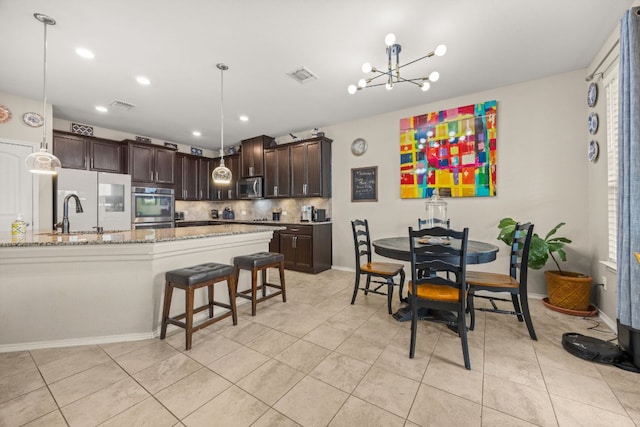 30336 Tiger Woods Dr, Georgetown, TX 78628 - dining space featuring a chandelier, light tile patterned floors, baseboards, and recessed lighting