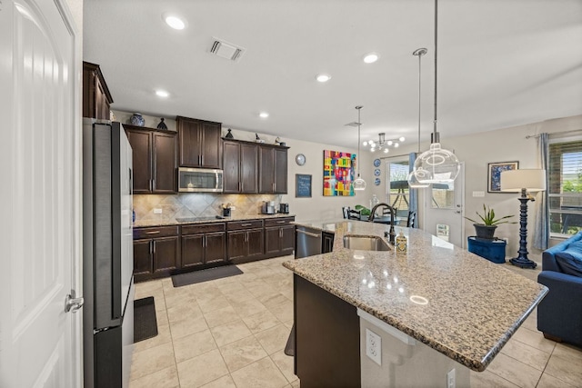 30336 Tiger Woods Dr, Georgetown, TX 78628 - kitchen featuring appliances with stainless steel finishes, plenty of natural light, a large island with sink, decorative backsplash, and recessed lighting