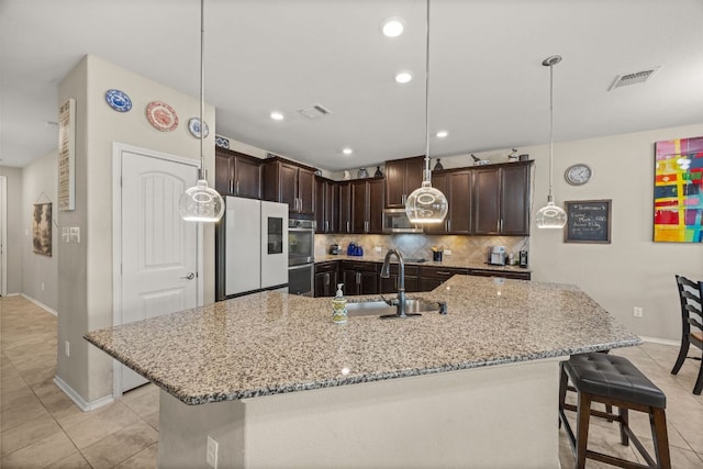 30336 Tiger Woods Dr, Georgetown, TX 78628 - kitchen featuring a sink, appliances with stainless steel finishes, baseboards, dark brown cabinets, and light tile patterned flooring