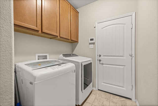 30336 Tiger Woods Dr, Georgetown, TX 78628 - laundry area with separate washer and dryer, cabinet space, baseboards, and light tile patterned flooring