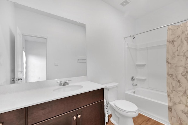 219 George Neggan Ln, Bastrop, TX 78602 - bathroom featuring visible vents, toilet, wood finished floors, vanity, and shower / bath combination with curtain