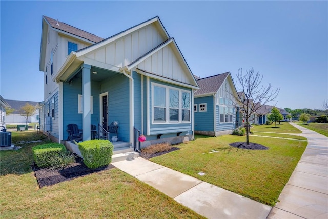 bungalow-style house featuring a front lawn, central AC unit, and board and batten siding