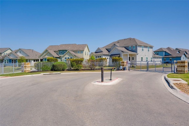view of road with a residential view, a gate, and curbs