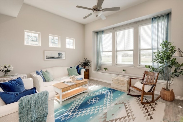 living room featuring baseboards and ceiling fan
