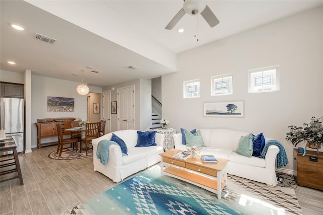 living area with ceiling fan, recessed lighting, stairs, and visible vents