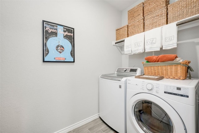 washroom with baseboards, washer and dryer, and laundry area