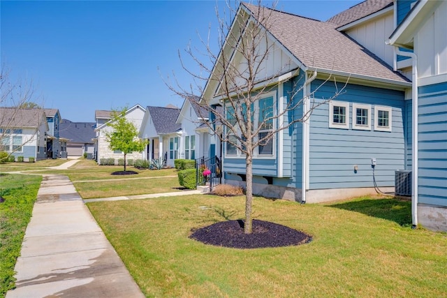 view of home's exterior featuring board and batten siding, a residential view, roof with shingles, and a yard